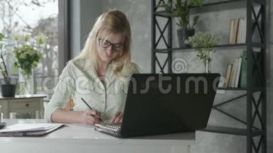 在线<strong>服务</strong>一位成功的女<strong>企业</strong>家在办公室的电脑上工作，鲜花在网上检查